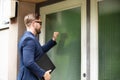 Man Standing In Front Of The House Knocking The Door