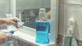 Man standing in front of mirror mouth washing and brushing his teeth in bathroom morning hygiene routine dental healthcare Royalty Free Stock Photo