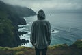 Man standing in front of the ocean and looking at the stormy sea - Generative AI Royalty Free Stock Photo