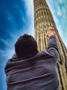 Photo of a man admiring a majestic saguaro cactus in the scenic Saguaro National Park
