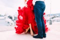 Man standing in front of a woman in a red gown on a boat pier in Montenegro Royalty Free Stock Photo