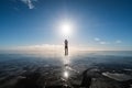 A man standing on frozen lake with sun and flare effects at winter