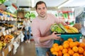 Man standing with full grocery cart during shopping in fruit shop Royalty Free Stock Photo