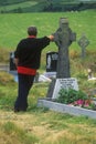 Man standing by grave marker in Kilcatherine Church cemetery, Cork, Ireland Royalty Free Stock Photo