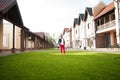 Man is standing on a green lawn of the cottage homes.