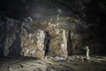 Man standing beside a group of stalactite cave