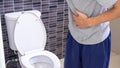 A man standing has diarrhea and severely toxic food. Man touch belly in the bathroom. Abdominal pain, Diarrhea,Colon cancer concep Royalty Free Stock Photo