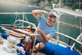 Man standing at helm of sailboat out at sea on a sunny afternoon Royalty Free Stock Photo