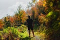 Man standing on a hiking trail with backpack on his back, surrounded with trees Royalty Free Stock Photo