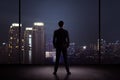 Man standing in his office looking at the city at night Royalty Free Stock Photo