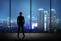 Man standing in his office looking at the city at night Royalty Free Stock Photo