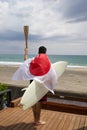 Man with Japanese flag , surfboard and torch used for sporting event.