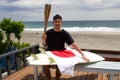 Man with Japanese flag , surfboard and torch used for sporting event.