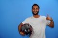 man standing and holding a halmet isolated on blue background