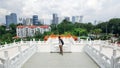 a man standing inside Thean Hou Temple facing the view of Kuala Lumpur skyscrapers