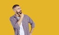 Man standing isolated on yellow background, looking at copy space and thinking about something Royalty Free Stock Photo