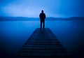 Man Standing on a Jetty by Tranquil Lake Concept