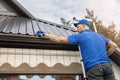 Man standing on ladder and cleaning roof rain gutter