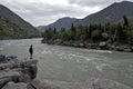 Man standing on a large rock spread his arms over mountain river Royalty Free Stock Photo