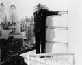 Man standing on the ledge of a building and looking feared Royalty Free Stock Photo