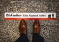 Man standing in line behind waiting sign in germany