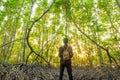 A man standing among mangrove forest with backpack Travel Lifestyle wanderlust adventure concept summer vacations outdoor alone in Royalty Free Stock Photo