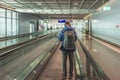 Man standing on a moving walkway at an airport