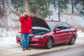 man standing near broken car with opened hood calling help