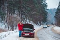 man standing near broken car with opened hood calling help