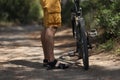 Man standing near mountain bike on path in forest closeup Royalty Free Stock Photo