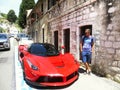 Man standing near the red sport car in ancient city
