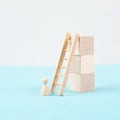 Man is standing next to a ladder, climbing up in career, having a goal, brainstorming for ideas, success strategy