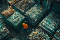 Man standing next to a large pile of sorted and baled plastic bottles for recycling Royalty Free Stock Photo