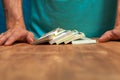 Man standing next to the table with currency heaps Royalty Free Stock Photo