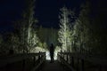 Man standing outdoor at dark night shining with flashlight Royalty Free Stock Photo