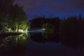 Man standing outdoor at dark night shining with flashlight Royalty Free Stock Photo