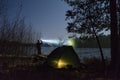 Man standing outdoor at dark night shining with flashlight. Royalty Free Stock Photo