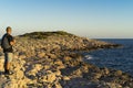 Man standing outdoors at stone beach close the Adriatic Sea in Croatia at sunset Royalty Free Stock Photo