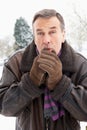 Man Standing Outside In Snow Warming Hands