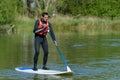 Man standing on paddleboard in water Royalty Free Stock Photo