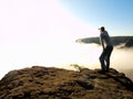 Man is standing on the peak of sandstone rock in national park Saxony Switzerland and watching over the morning misty valley Royalty Free Stock Photo