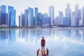 Man standing on the pier looking at modern cityscape skyline