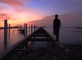 Man Standing pier at sunsets Royalty Free Stock Photo