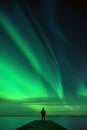 Man standing on pier and watching Northern Lights dancing across night sky Royalty Free Stock Photo