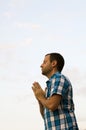 Man standing and praying on a hillside. Royalty Free Stock Photo