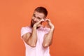 Man standing with raised hands and making heart or love gesture, looking at camera with toothy smile Royalty Free Stock Photo