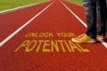 Man standing on the running track with a motivational quote written : Unlock Your Potential