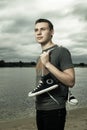 Man standing on the river bank with trainers