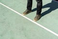 Man standing on rubberized ground with white race line, beginning idea