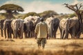 A man standing in savannah and looking at group of elephants generative AI